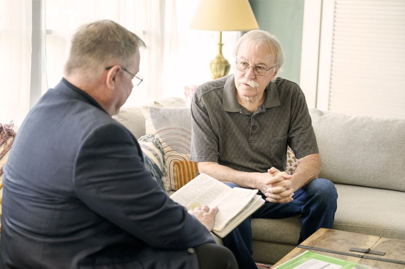 A spiritual counselor is talking with a hospice patient and their family.