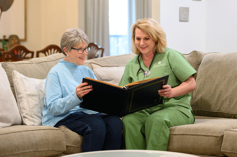 A hospice clinician and caregiver looking at memories