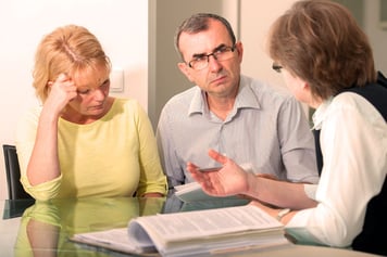 A man and woman discuss hospice coverage with provider