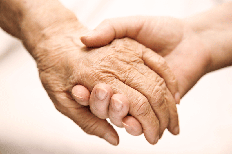 Holding terminal hospice patient's hand