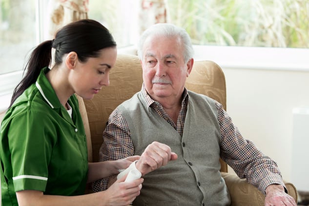 nurse bandaging senior adult's arm