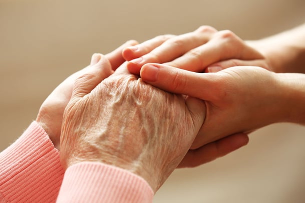hands holding elderly hands in comfort