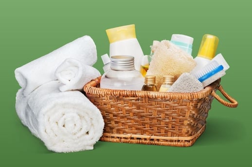 Bathroom supplies neatly organized in a basket next to folded towels