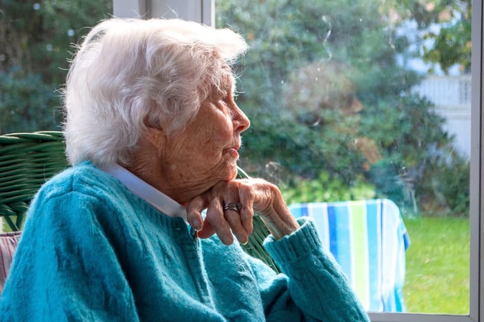 elderly woman looking out a window
