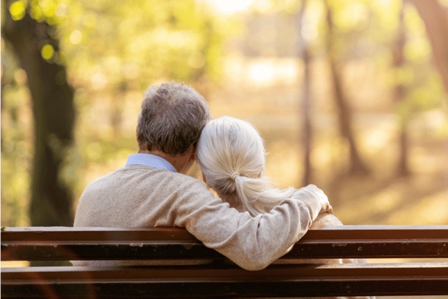 older couple embracing on a park bench
