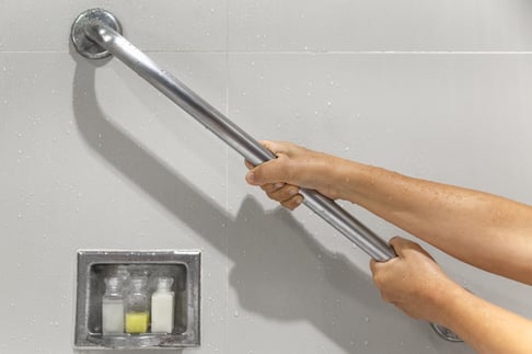 Arms grabbing a bar inside a bath area