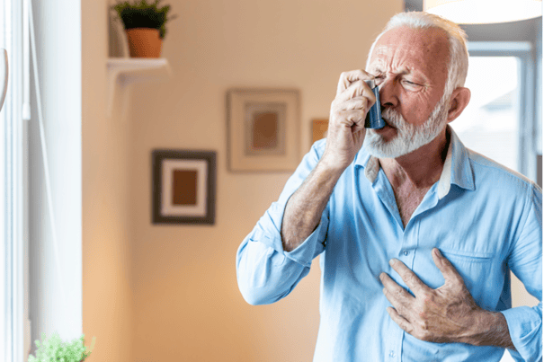 elderly man using an inhaler