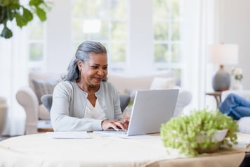Older woman looking at information on a laptop