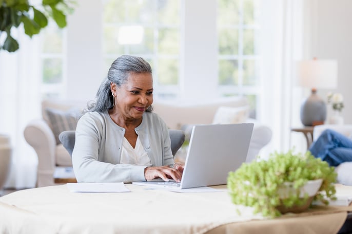 elderly woman looking at a laptop