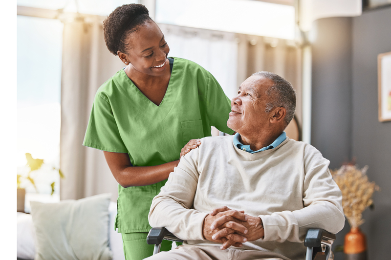 nurse in green scrubs smiling at older patient