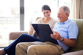 older man reviewing a photo album with a woman