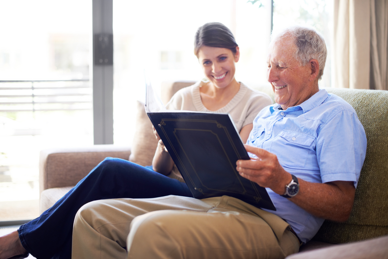 older man reviewing a photo album with a woman