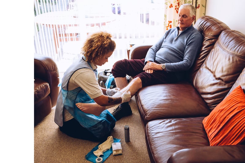 nurse dressing patient's wound at home