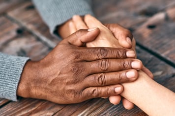 caring hands holding a hand for comfort